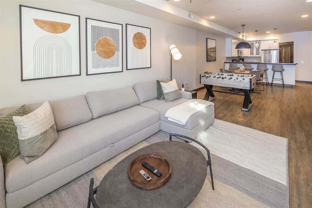 A modern living room with a sofa, coffee table, and artwork on the wall.
