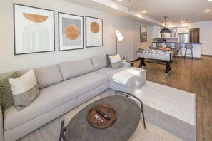 A modern living room with a sofa, coffee table, and artwork on the wall.