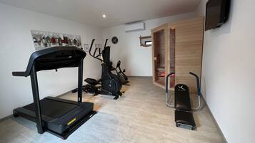 A home gym with a treadmill, elliptical, and stationary bike.