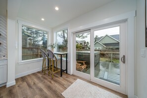 Enjoy a serene view from the deck, featuring a large sliding glass door and a small dining area.