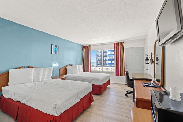A hotel room with two beds, a desk, a chair, a TV, and a window with curtains. - The Anchor Hotel (Myrtle Beach)