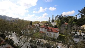 Un quartiere residenziale con case dai tetti in tegole rosse, immerso nel verde e con uno sfondo collinare.