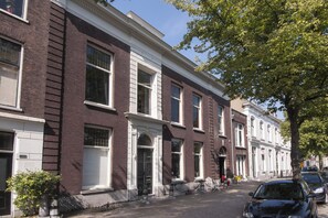 A row of brick townhouses with white trim, large windows, and a tree-lined street. - Canal-view Studio Sleeps 2 - Pets Welcome - Wifi (Schiedam)