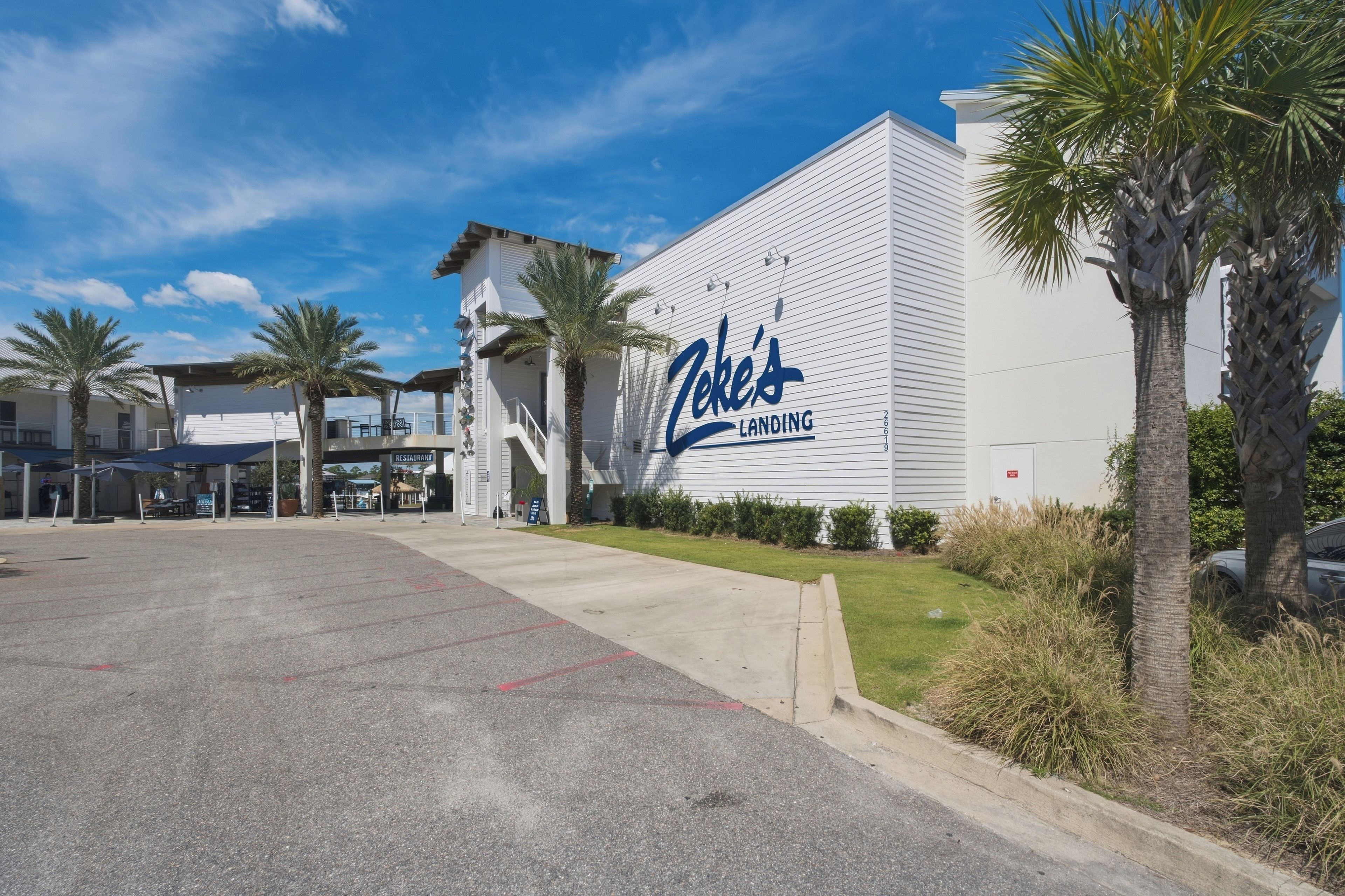 A building with a large sign reading 'Coke's Landing' and a parking lot in front.