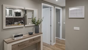 Een moderne badkamer met een wastafel, een spiegel, een magnetron en een potplant.