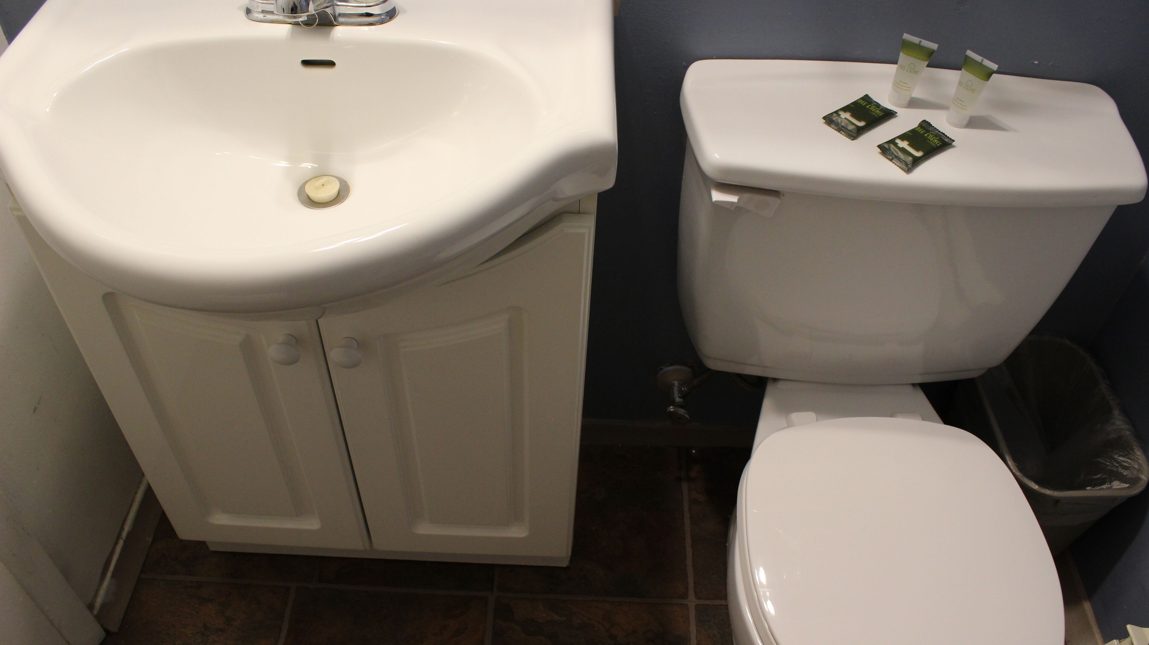 Un baño con lavamanos, inodoro y mueble blanco.