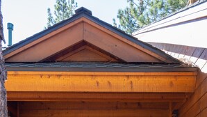 A wooden cabin entrance with a double door, a small porch, and a wooden railing. - Creekside Lodge on GC w/ AC & Pool Table (Truckee)