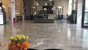 A lobby with a reception desk, seating area, and a decorative flower arrangement. - Echarm Hotel (Hong'an Zidong Xincheng) (Hong'an)