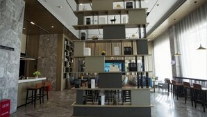 A modern interior with a central seating area, a bar, and a shelving unit with various items. - Echarm Hotel (Hong'an Zidong Xincheng) (Hong'an)