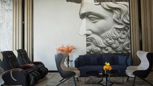 A modern lounge area with a large wall mural, seating, and a vase with flowers. - Echarm Hotel (Hong'an Zidong Xincheng) (Hong'an)