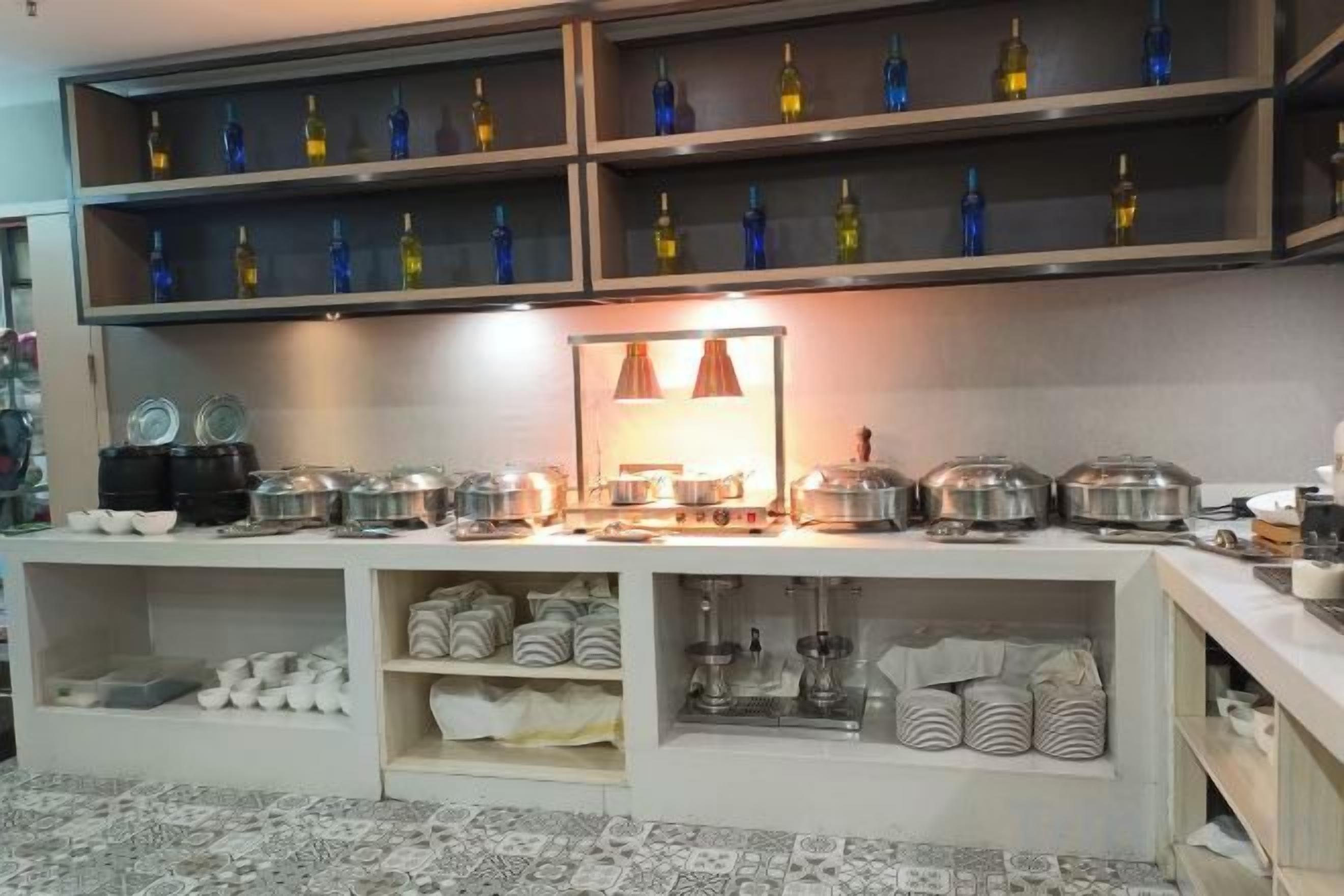 A buffet setup with multiple serving stations, glassware, and neatly arranged linens.
