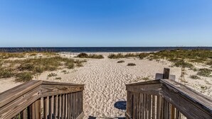 A wooden boardwalk leading to a sandy beach with dunes and a clear blue sky. - Sensational Sandcastles Condo/Oceanfront-Amelia (Fernandina Beach)