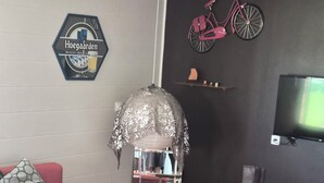 A living room with a sofa, a stop sign table, a television, and a bicycle wall art piece.
