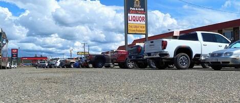 Un estacionamiento con un letrero que anuncia un restaurante familiar, un bar-restaurante y una licorería.