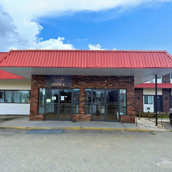 Un bâtiment avec un toit rouge et une enseigne sur laquelle on peut lire « Nihsin Office ».