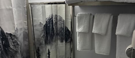 Un baño con lavamanos, espejo, toallero y secador de pelo.