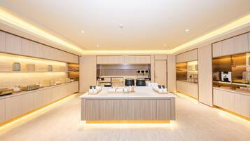 A modern kitchen with a central island, wooden cabinetry, and built-in appliances.