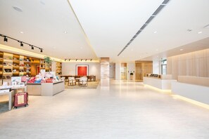 A modern hotel lobby with a reception desk, a seating area, and a bookstore. - Ji Hotel Xingtai Museum Store (Xingtai)