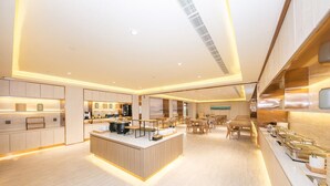 A modern hotel lobby with a central island, seating area, and a kitchen counter. - Ji Hotel Xingtai Museum Store (Xingtai)