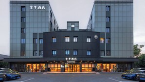 A hotel with a modern design, featuring a central entrance with a glass facade and multiple windows. - Ji Hotel (Nanchang)
