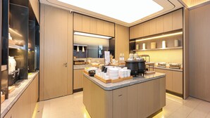 A modern kitchen with a central island, built-in appliances, and ample counter space. - Ji Hotel (Nanchang)
