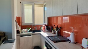 Una cucina con lavastoviglie, lavello, finestra e diversi utensili da cucina.