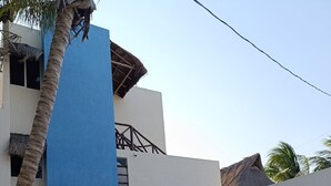 A building with a blue facade, a thatched roof, and a sign indicating a call center. - Lila-Mar Telchac (Telchac puerto)