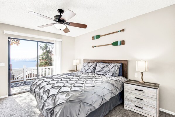 A bedroom with a bed, a nightstand, a ceiling fan, and a view of the outdoors. - Waterview Margaritaville Resort area home. Practice golf! Outdoor TV/grill (Osage Beach)