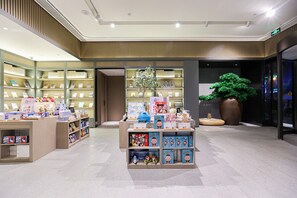 A bookstore with shelves of books and a display of children's toys. - Ji Hotel (Chengdu)