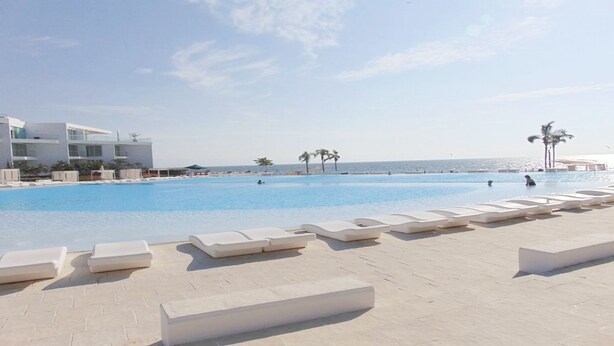 A large swimming pool with lounge chairs and a view of the ocean. - Condo Aria Ocean 306 (Nuevo Nayarit)
