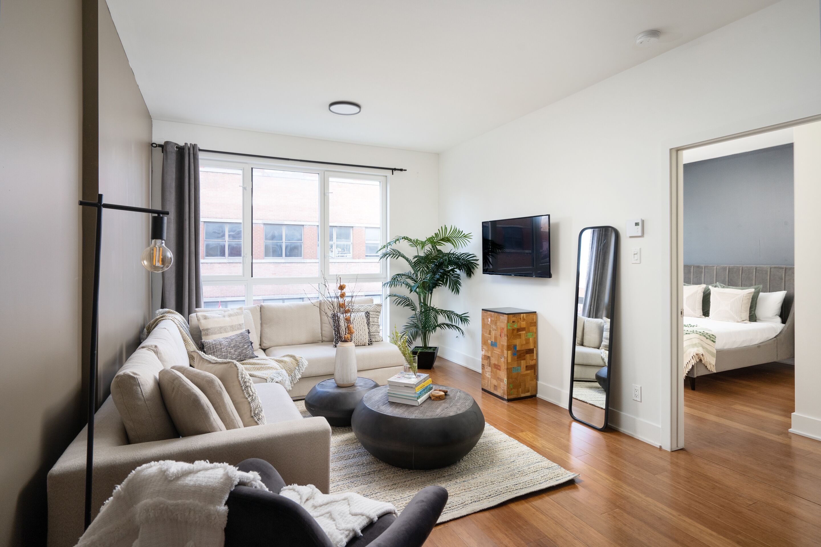 A modern living room with a sofa, coffee table, and a large window.