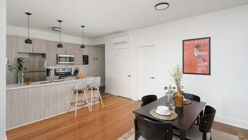 Cocina moderna con microondas, estufa y lavabo. Hay un comedor con mesa y sillas.
