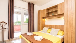 Ein Hotelzimmer mit einem Bett, einem Holzkopfstück und einem kleinen Regal darüber.