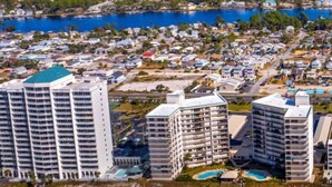 A coastal cityscape with high-rise buildings, a marina, and a beach. - Seaside Serenity (Panama City Beach)