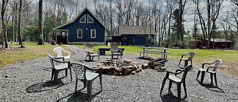 A rustic cabin with a fire pit and outdoor seating.