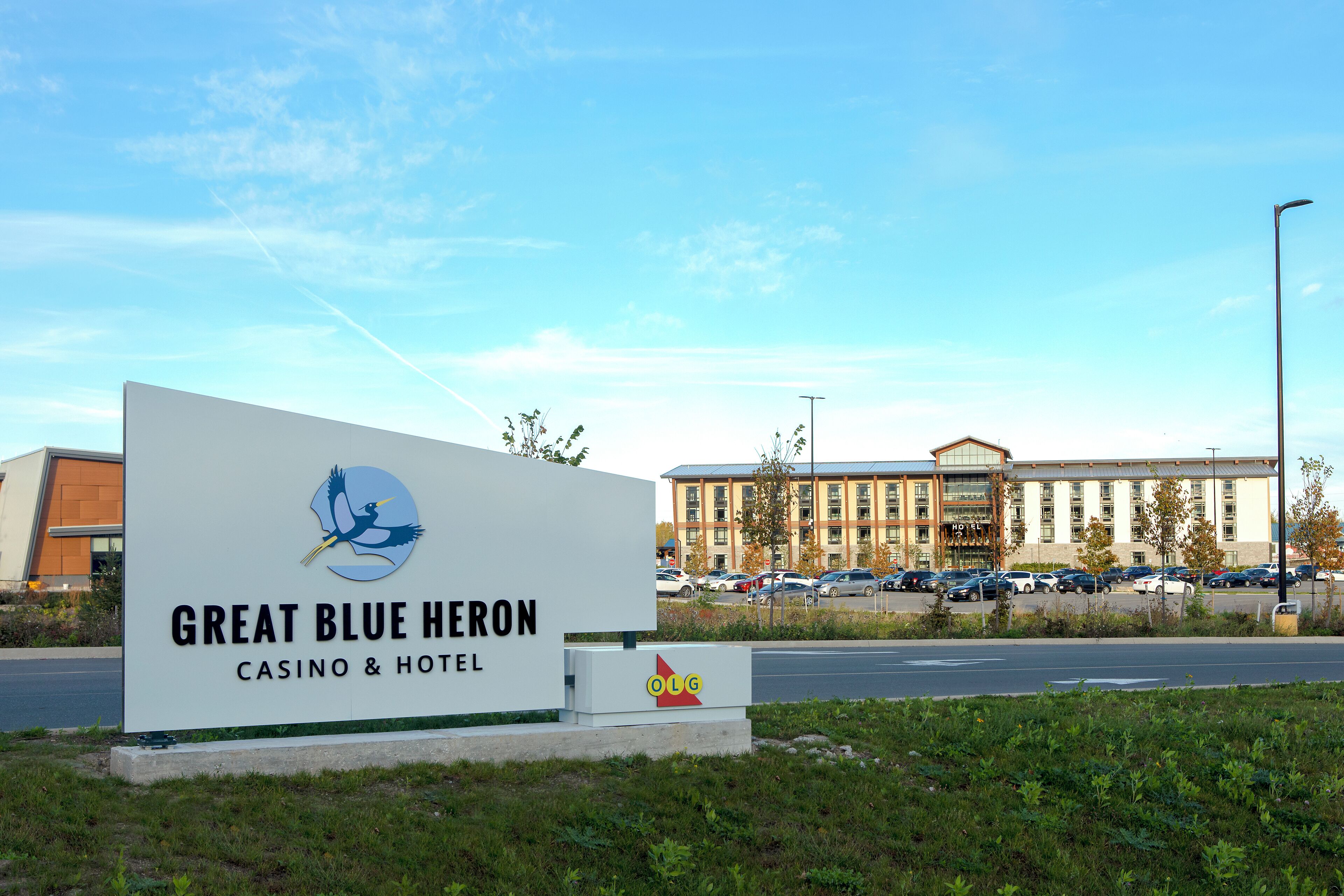 Señal del casino y hotel Great Blue Heron, con un edificio moderno al fondo.