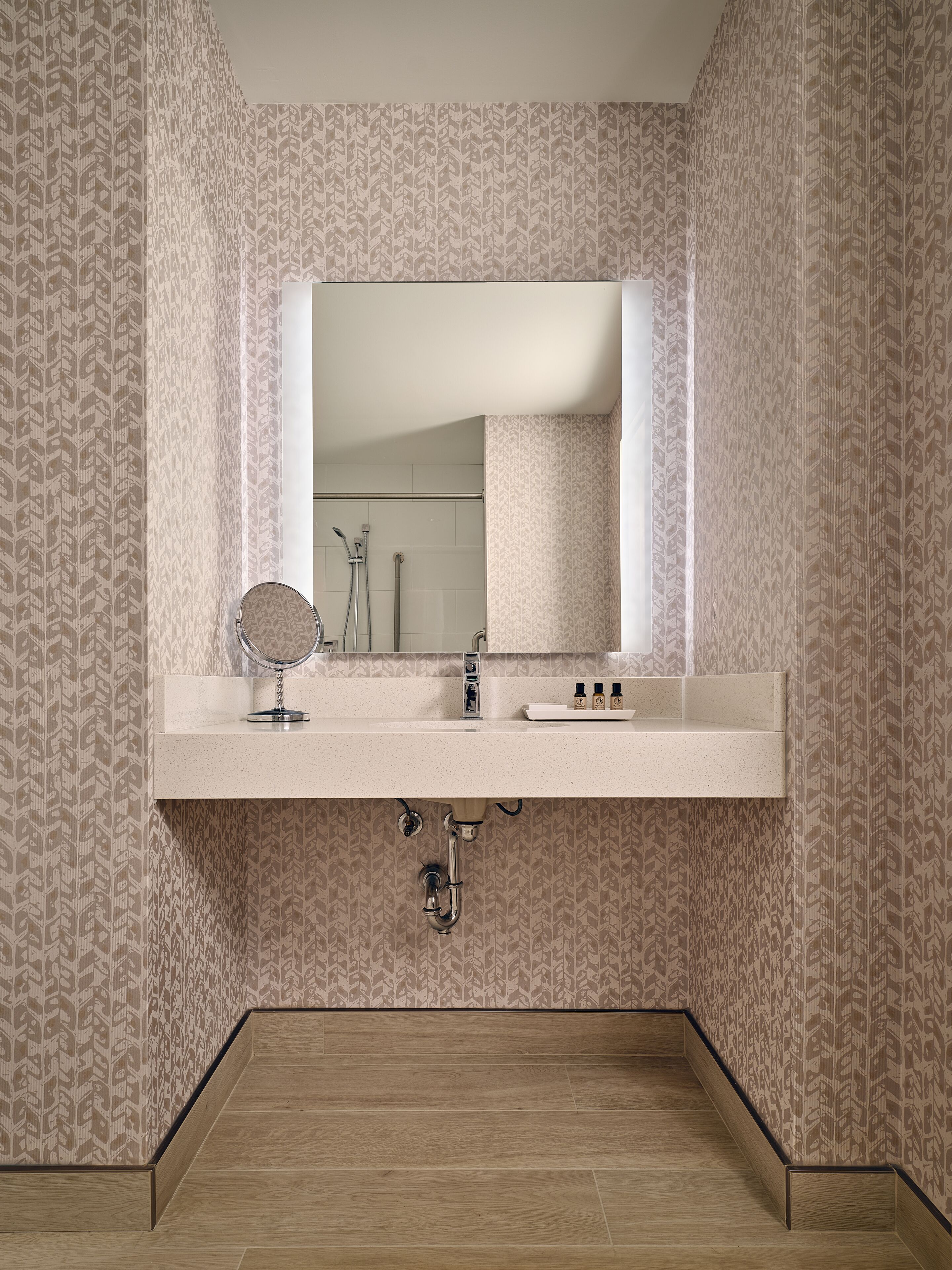 Une salle de bain avec un meuble-lavabo, un miroir et une douche.