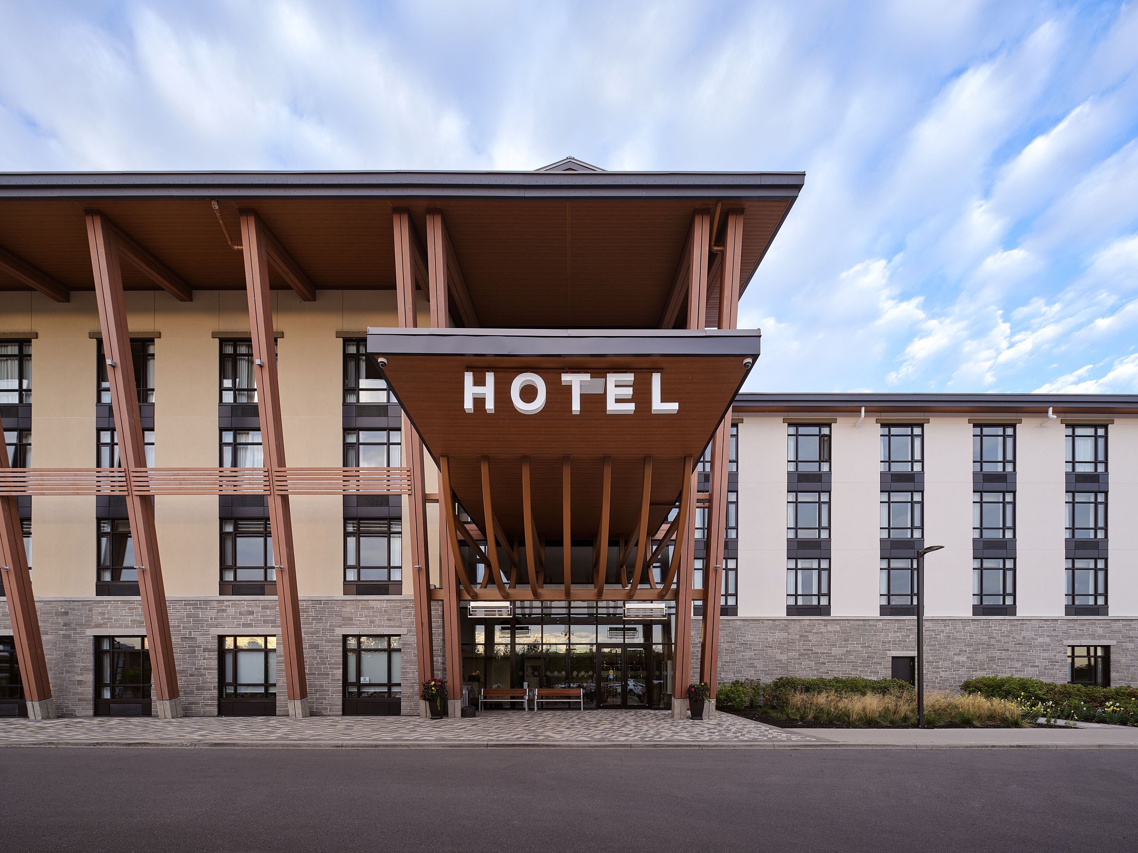 A hotel with a prominent entrance, large windows, and a modern architectural design.