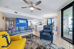 A living room with a sofa, armchair, and a ceiling fan.