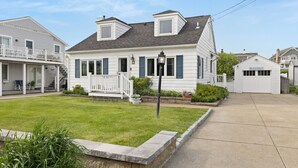 A two-story house with a front porch, a garage, and a well-maintained lawn.