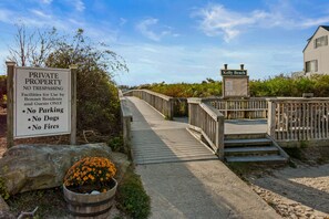Schild für Privatgrundstück mit Beschränkungen, eine Holzbrücke und ein Strandhaus namens Kelly Beach.
