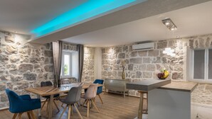 Un espace repas agrémenté d’un mur en pierre, d’une table en bois et de chaises modernes.