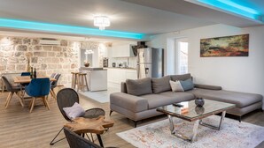 Un salon moderne avec un canapé, une table basse et un coin repas.