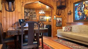 Un intérieur en bois comprenant une table à manger, des chaises, un canapé et un tapis.