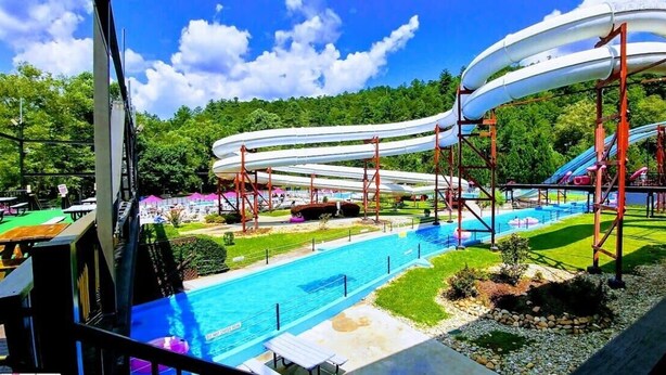 Ein Wasserpark mit mehreren Wasserrutschen, einem Schwimmbecken und Picknickplätzen.
