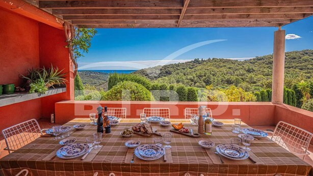 Comedor con una mesa dispuesta para seis personas, con vistas a un paisaje pintoresco.