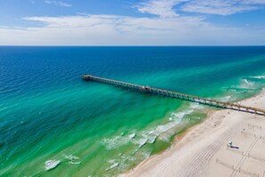 An aerial view of a beach with a long pier extending into the ocean. - Calypso Resorts Tower III Unit 310 (Panama City Beach)