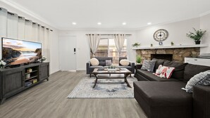 Una sala de estar con televisión, sofá y mesa de centro.