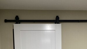 A white sliding door with a black handle and a black track above it.