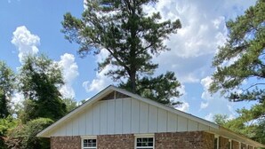 A single-story stone building with a gabled roof and two windows.